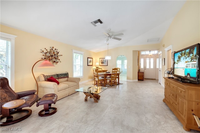 living room with a wealth of natural light, ceiling fan, and lofted ceiling