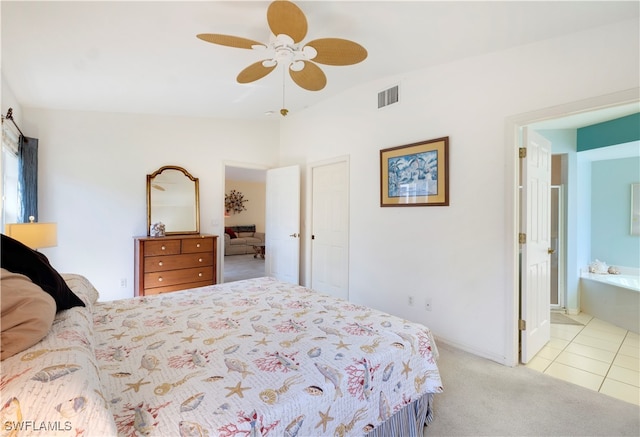 bedroom with ceiling fan, light colored carpet, lofted ceiling, and connected bathroom