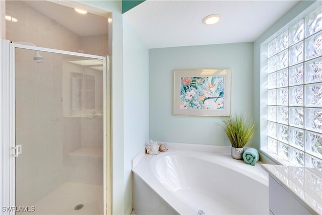 bathroom with a wealth of natural light, vanity, and independent shower and bath