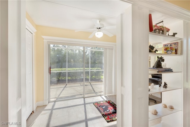 doorway to outside with ceiling fan and light tile patterned floors