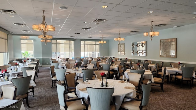 dining area featuring a paneled ceiling and dark carpet