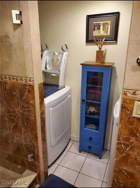 clothes washing area featuring light tile patterned floors and washer / clothes dryer