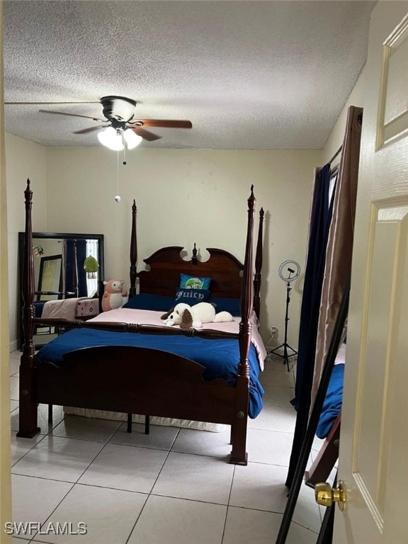 bedroom with ceiling fan, a textured ceiling, and light tile patterned floors