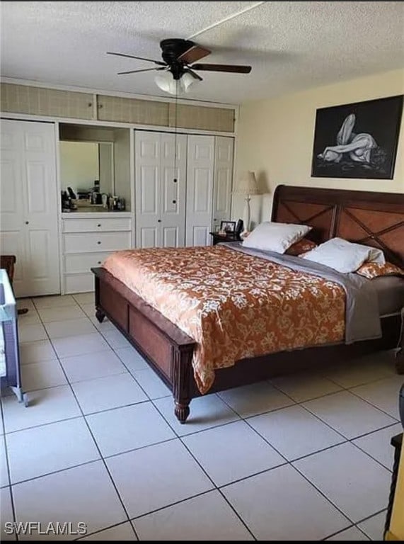 bedroom featuring ceiling fan, a textured ceiling, and light tile patterned floors