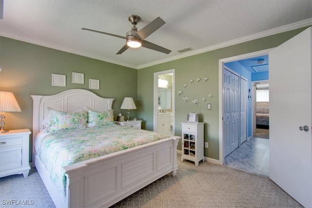 carpeted bedroom with ornamental molding, a closet, ceiling fan, and ensuite bathroom