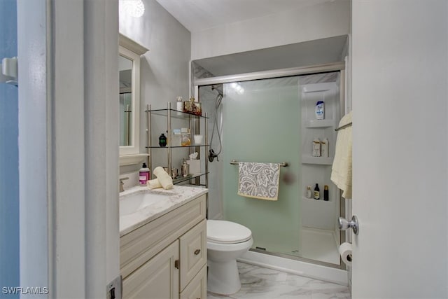 bathroom featuring a shower with shower door, vanity, and toilet