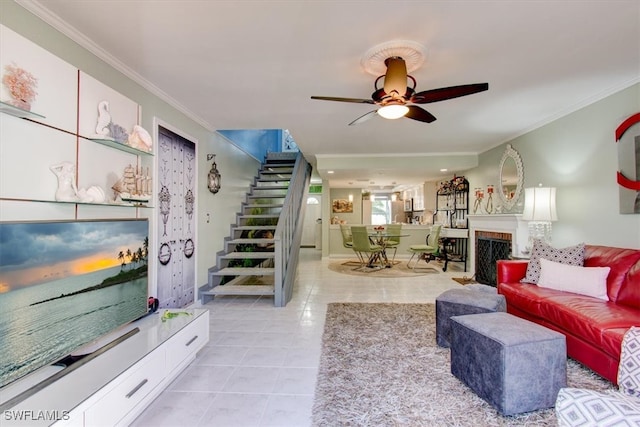 living room with light tile patterned flooring, ceiling fan, and crown molding