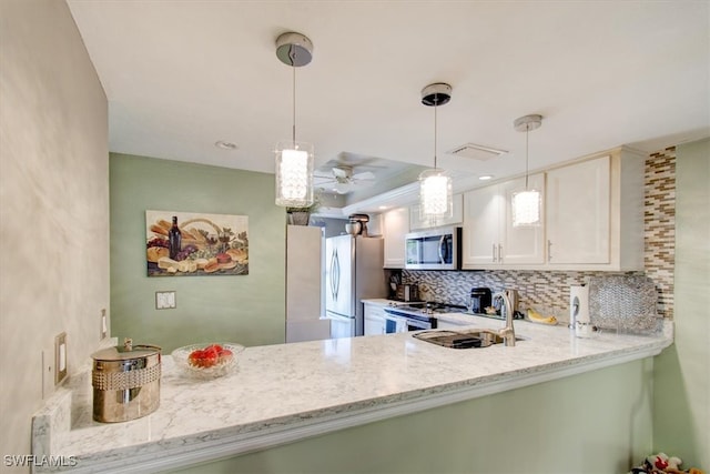 kitchen featuring white cabinets, hanging light fixtures, light stone counters, and appliances with stainless steel finishes