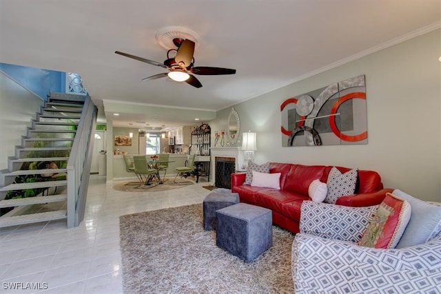 living room featuring tile patterned flooring, ceiling fan, and crown molding