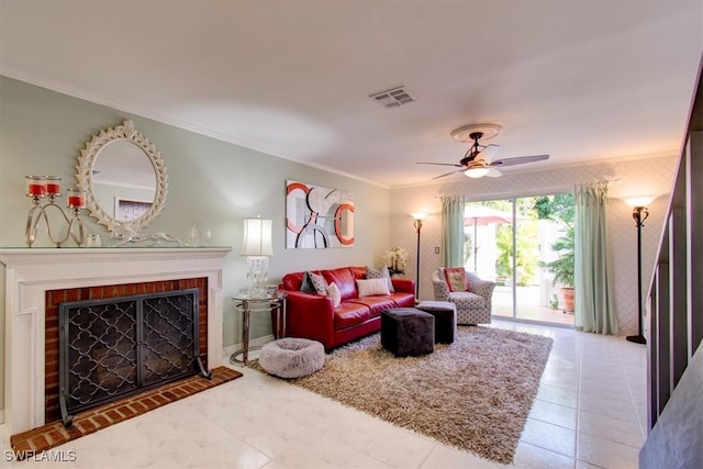 living room with ornamental molding, a fireplace, ceiling fan, and tile patterned floors