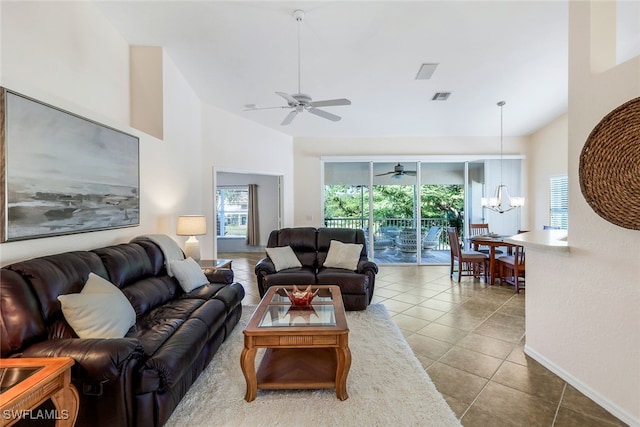 living room featuring high vaulted ceiling, tile patterned floors, and ceiling fan with notable chandelier