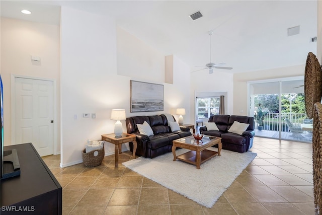 tiled living room with ceiling fan and a towering ceiling