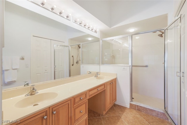 bathroom featuring walk in shower, vanity, and tile patterned floors