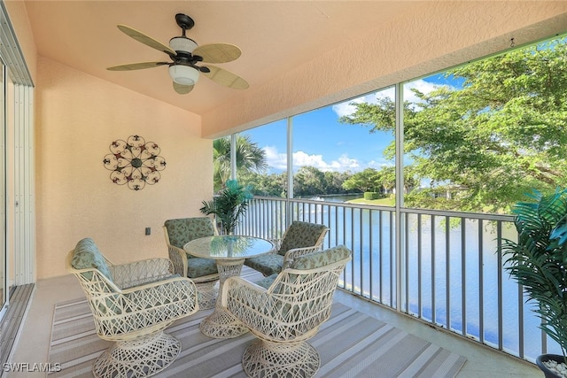 sunroom / solarium featuring a water view, ceiling fan, and lofted ceiling