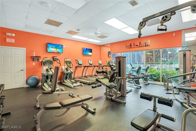 exercise room with ceiling fan and a drop ceiling