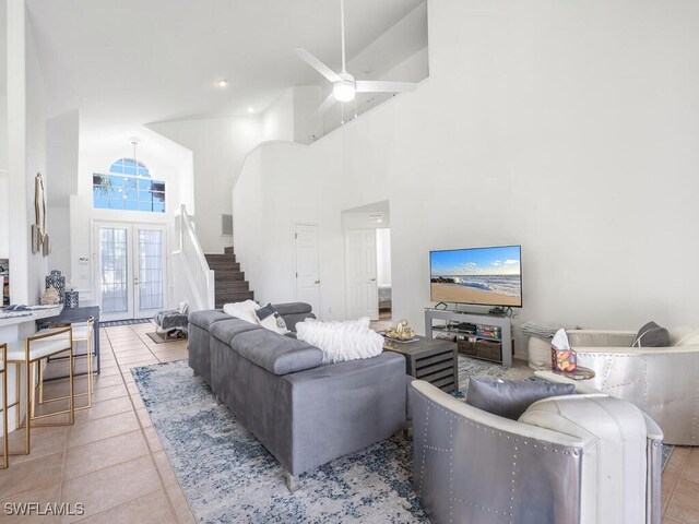 tiled living room featuring ceiling fan and a high ceiling