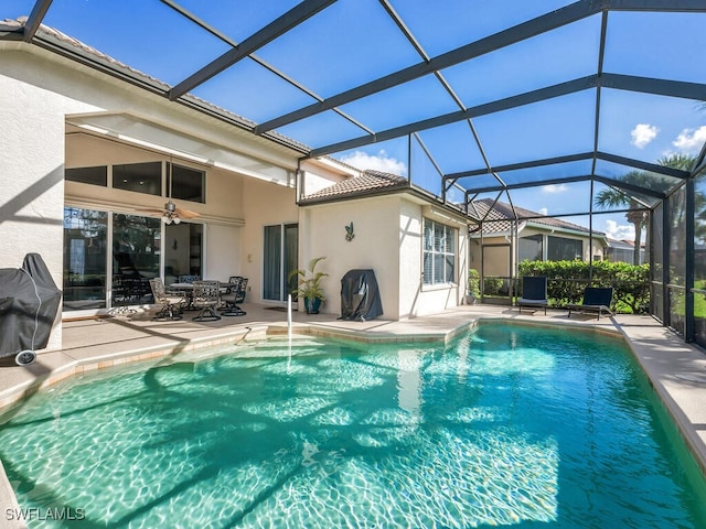 view of pool with glass enclosure and a patio area