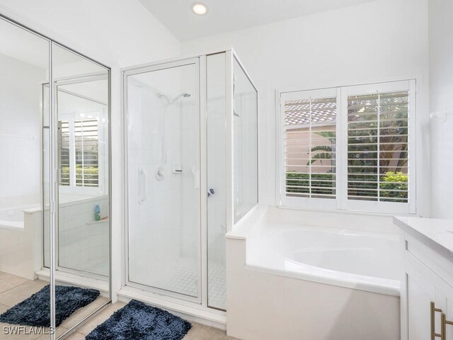 bathroom featuring vanity, tile patterned flooring, and plus walk in shower