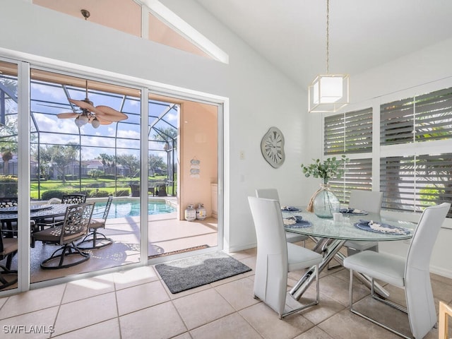 dining room with ceiling fan, light tile patterned floors, lofted ceiling, and a wealth of natural light