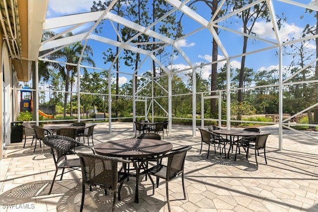 view of patio featuring glass enclosure