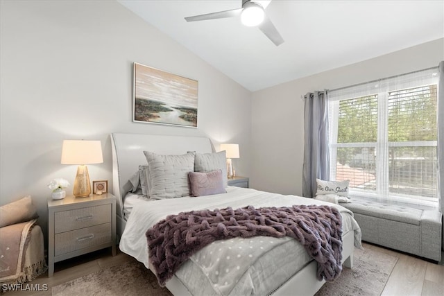 bedroom featuring ceiling fan, lofted ceiling, and light wood-type flooring