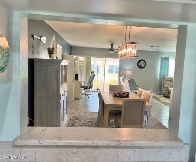 tiled dining space with a chandelier