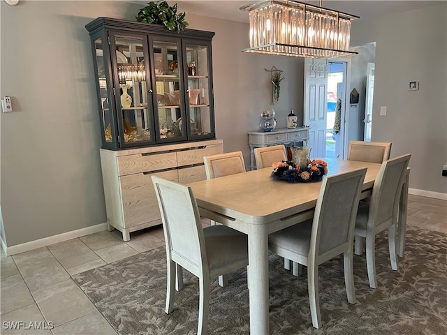 tiled dining room featuring a chandelier