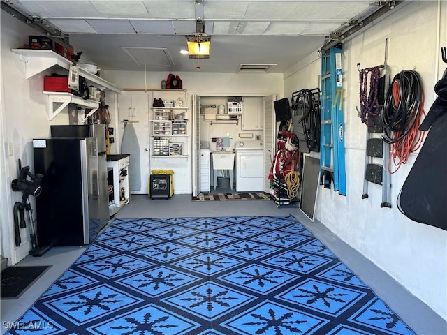 garage featuring washer / dryer, visible vents, a garage door opener, and freestanding refrigerator