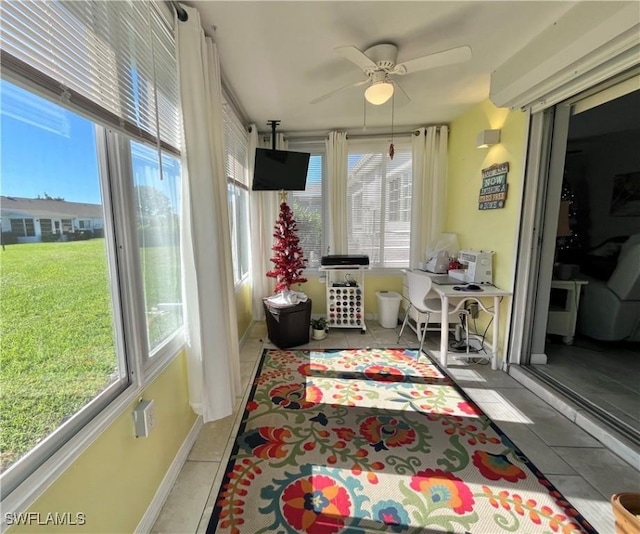 sunroom / solarium featuring a healthy amount of sunlight and ceiling fan