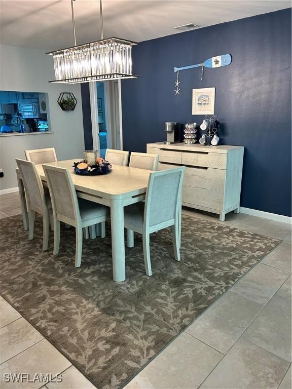 tiled dining space with visible vents and baseboards