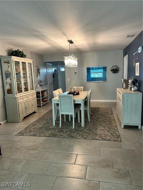 dining area featuring a chandelier, visible vents, and baseboards