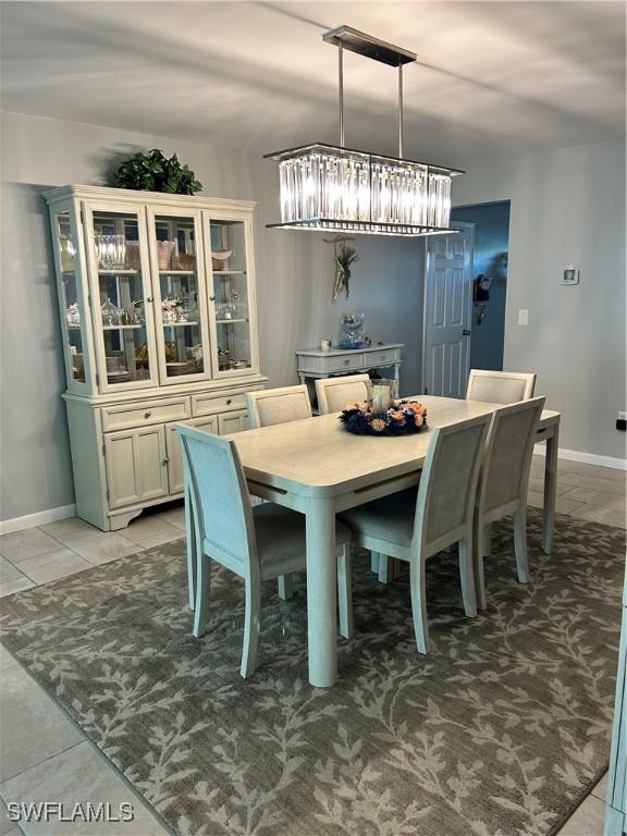 dining space with light tile patterned floors and baseboards