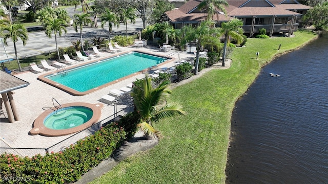 view of pool featuring a patio area, a yard, and a water view