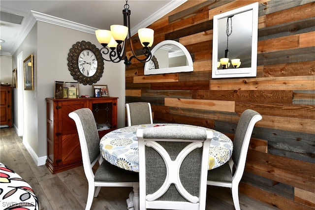 dining room with wooden walls, crown molding, dark wood-type flooring, and a notable chandelier