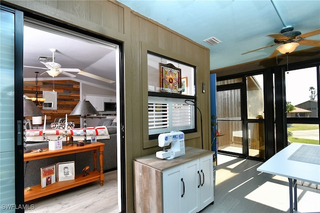 entryway featuring wooden walls, light hardwood / wood-style flooring, and vaulted ceiling