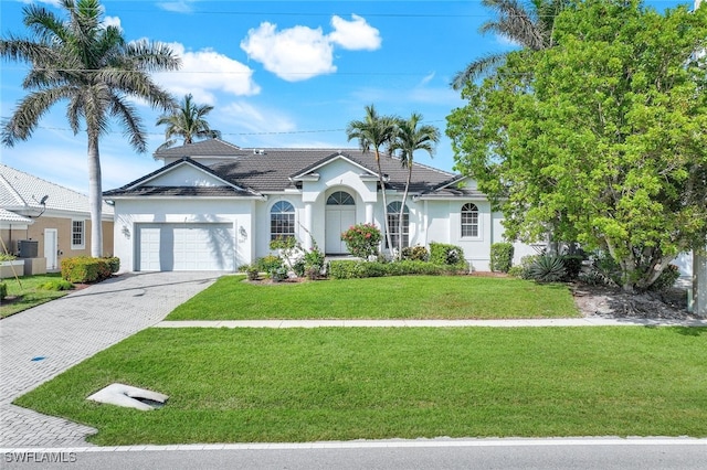 view of front of home with a front yard and a garage