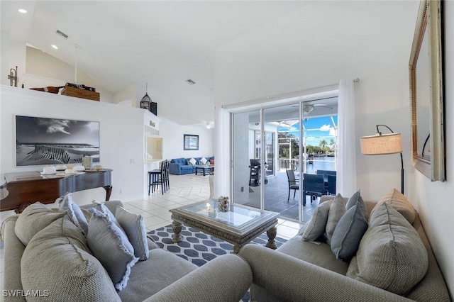 living room featuring a water view, ceiling fan, light tile patterned flooring, and high vaulted ceiling