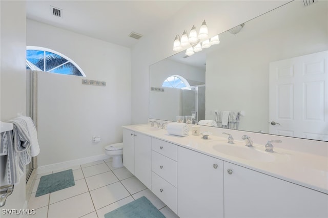 bathroom featuring tile patterned flooring, vanity, toilet, and a shower with door