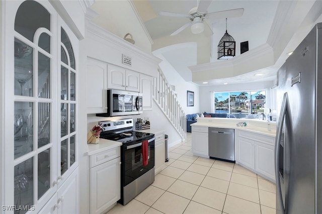 kitchen featuring ceiling fan, light tile patterned floors, lofted ceiling, white cabinets, and appliances with stainless steel finishes