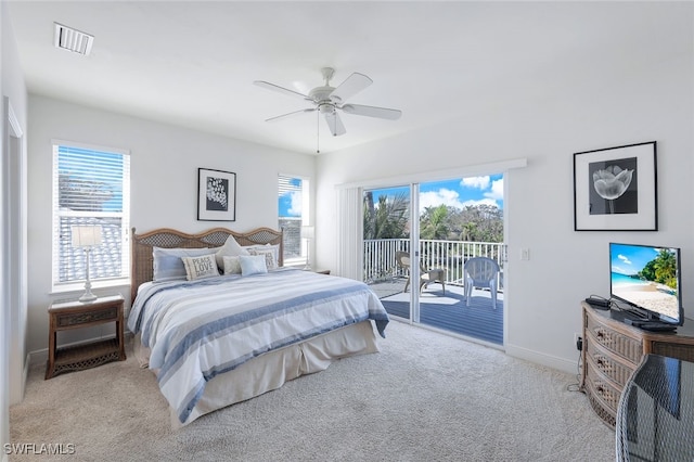 bedroom with ceiling fan, access to exterior, light carpet, and multiple windows