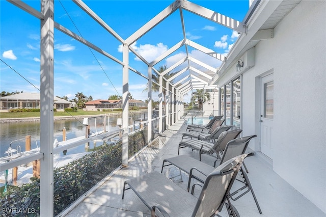 view of patio / terrace featuring a water view and a lanai