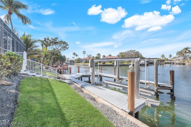 dock area with a lawn and a water view