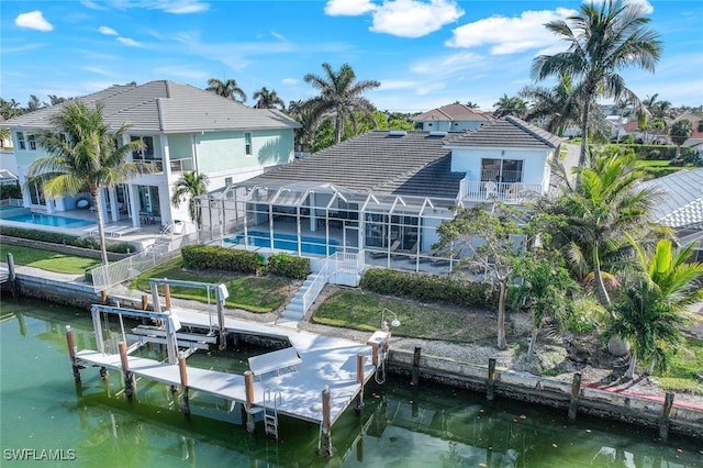 back of property featuring glass enclosure, a balcony, a patio, and a water view