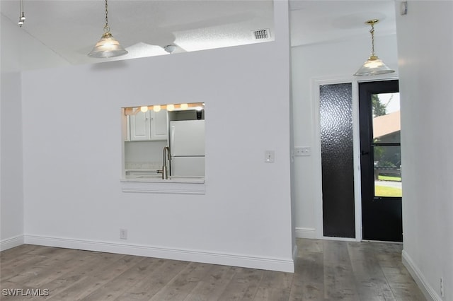 empty room with sink, wood-type flooring, and a textured ceiling