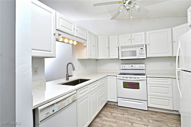 kitchen featuring light wood-type flooring, white appliances, sink, white cabinetry, and lofted ceiling