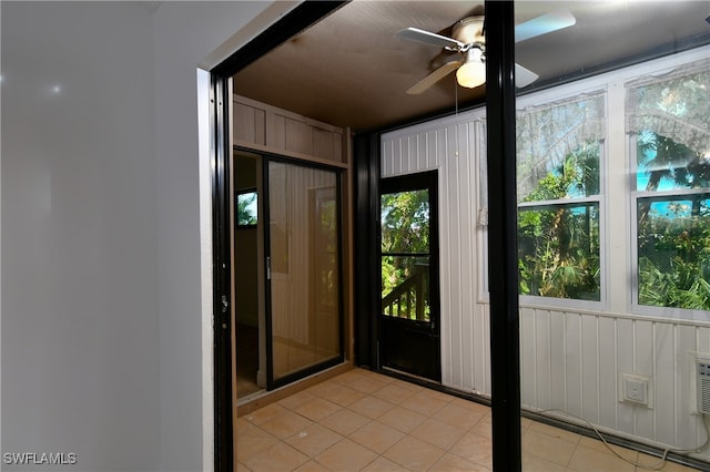 doorway featuring ceiling fan and light tile patterned floors