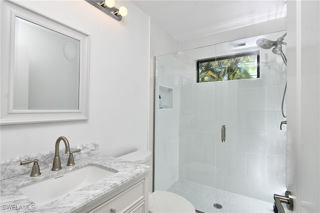 bathroom with a shower with door, vanity, and toilet