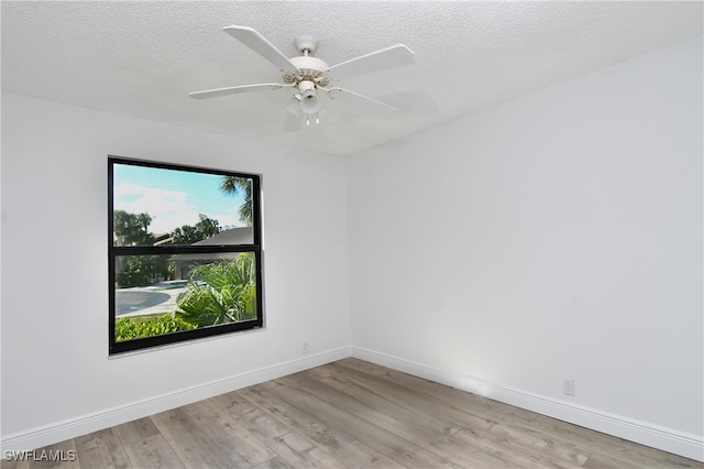 empty room featuring ceiling fan, a textured ceiling, and light wood-type flooring