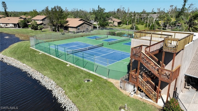 view of tennis court with a water view