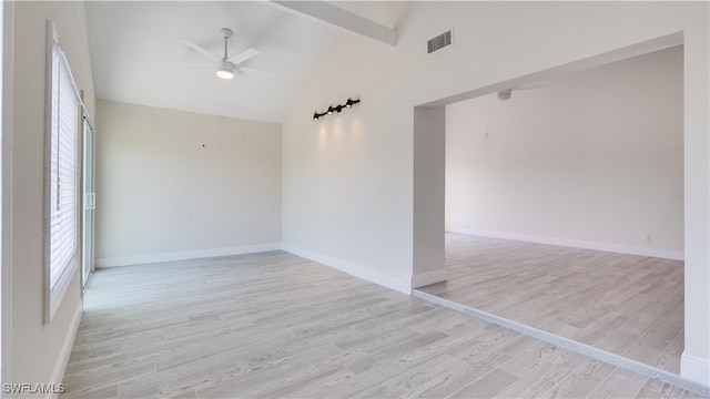 empty room with ceiling fan, a healthy amount of sunlight, light wood-type flooring, and beam ceiling